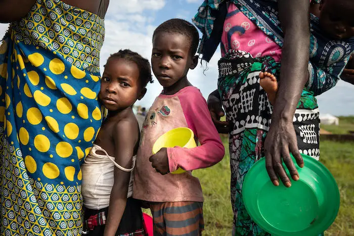 Outside the city of Beira, Mozambique, children queue for food at a UNICEF-supported relocation center sheltering families displaced by Tropical Cyclone Eloise. Outside the city of Beira, Mozambique, children queue for food at a UNICEF-supported relocation center sheltering families displaced by Tropical Cyclone Eloise.