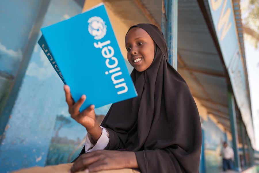 Child Reading UNICEF Book