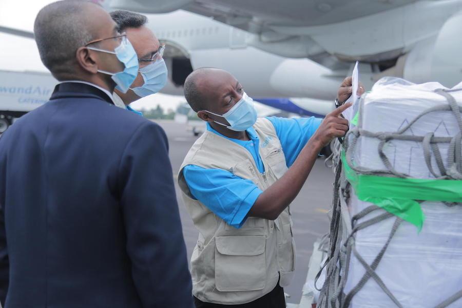 On March 3, 2021, UNICEF Supply Officer Mr. Denis Mupenzi, centre, inspects the cargo containing 240,000 doses of the COVID-19 vaccines for the COVAX Facility at Kigali International Airport in Rwanda.