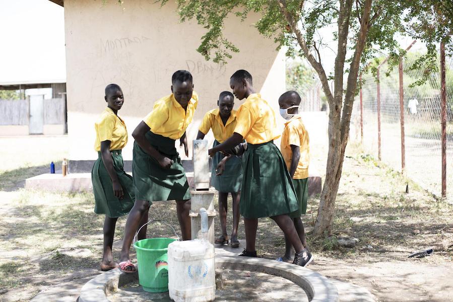 At Dumak Primary School in Torit, South Sudan on February 2, 2021, students fill buckets with safe water from a borehole rehabilitated by UNICEF and partners.