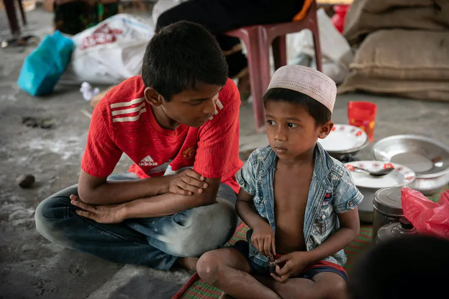 Mohammad Faisal, 18, comforts a younger Rohingya refugee while the child’s family goes for help after their home was lost to the fire that devastated the Balukhali area of the Rohingya refugee camps in Cox’s Bazar, Bangladesh. Mohammad Faisal, 18, comforts a younger Rohingya refugee while the child’s family goes for help after their home was lost to the fire that devastated the Balukhali area of the Rohingya refugee camps in Cox’s Bazar, Bangladesh.