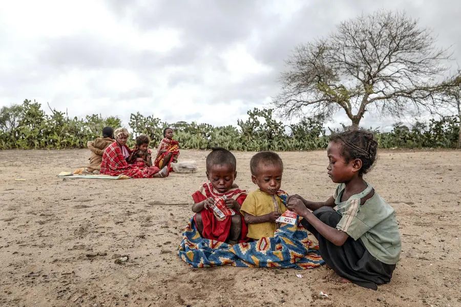 An older sibling gives therapeutic food to Samberahae, 3, and Fedraza, 2. The nutrient-rich peanut paste comes in packets that make it easy to distribute and use. An older sibling gives therapeutic food to Samberahae, 3, and Fedraza, 2. The nutrient-rich peanut paste comes in packets that make it easy to distribute and use.