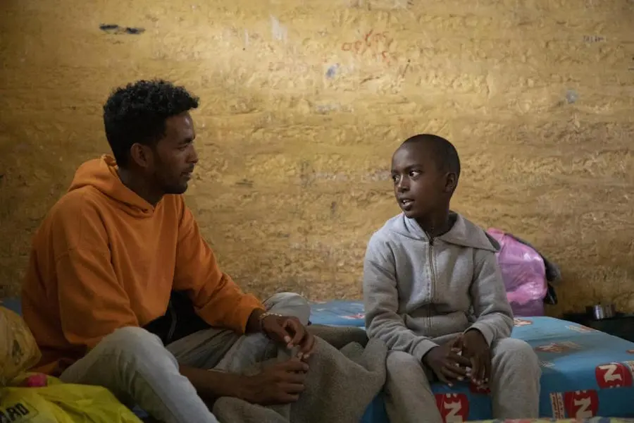 Displaced from his home by conflict in northern Ethiopia, 11-year-old Temesgen, right, is living with his family in an emergency shelter in a school in Mekelle in 2021. Displaced from his home by conflict in northern Ethiopia, 11-year-old Temesgen, right, is living with his family in an emergency shelter in a school in Mekelle in 2021.