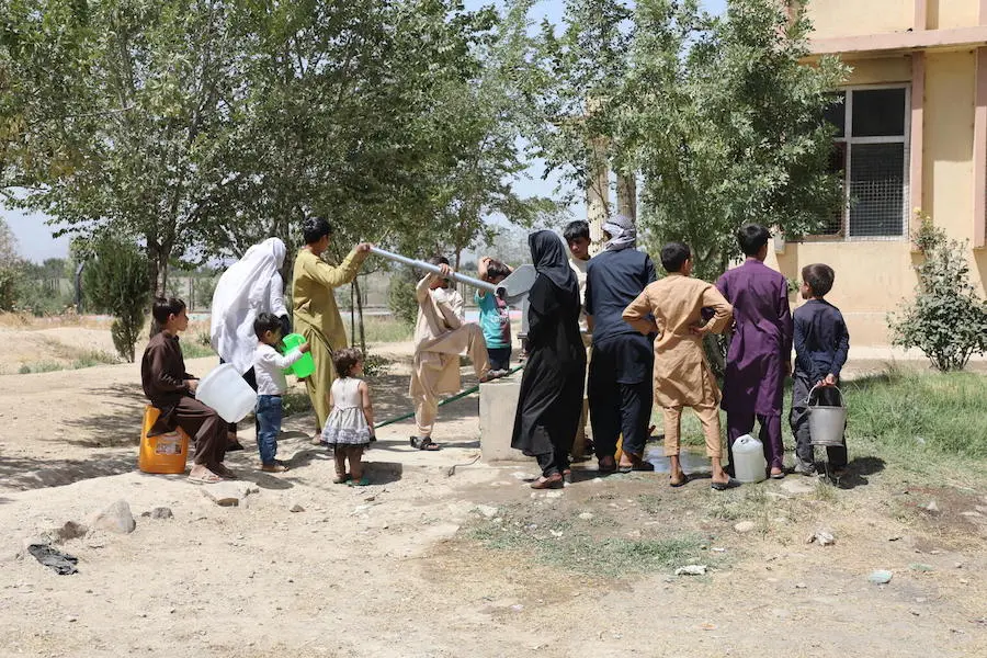 Children gather around a water pump in Peer Mohammad Kakar high school now hosting more than 400 families fleeing instability and conflict to Kabul. Children gather around a water pump in Peer Mohammad Kakar high school now hosting more than 400 families fleeing instability and conflict to Kabul.