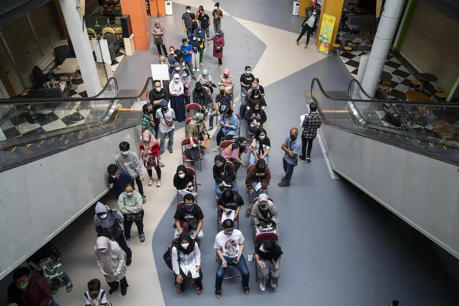 People line up to receive their COVID-19 vaccination at the Cilandak Town Square Mall in South Jakarta, Indonesia, on August 24, 2021. People line up to receive their COVID-19 vacciation at the Cilandak Town Square Mall in South Jakarta, Indonesia, on August 24, 2021.