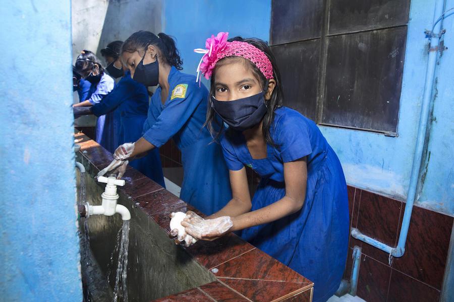 On September 12, 2021, children wash their hands properly before entering the classroom at Kalamarchara Government Primary School in Cox’s Bazar, Bangladesh. 