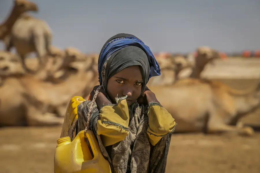 Sulem Hire 9, carries the jerry can holding water to her home which is four kilometers away from the borehole.