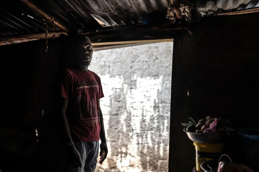Person Standing in Doorway of Shack