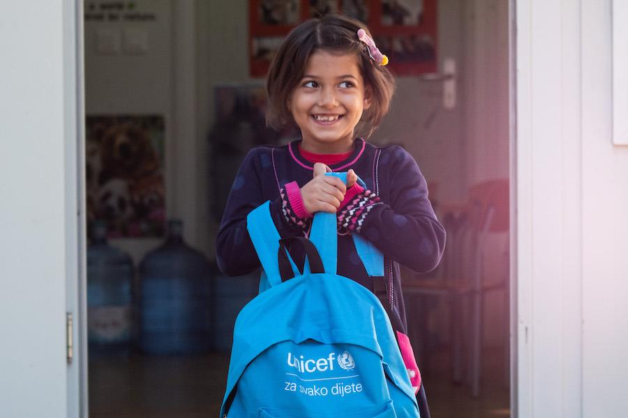 A child refugee from Afghanistan who has traveled from Afghanistan with her parents through Turkey, Greece, Albania and Montenegro to find a home is eager to get to school and start using the school supplies loaded into her UNICEF backpack. 