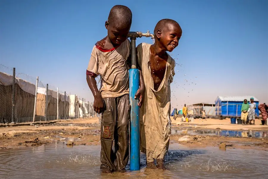 Children play under a water tap during a recess at a UNICEF supported primary school inside Bukasi Internally Displaced People's camp, in Maiduguri, Borno State, Nigeria