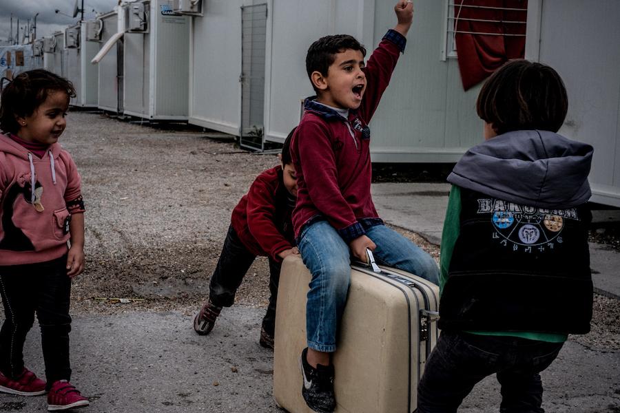 Children play with a suitcase they found in the garbage at the Skaramagas refugee camp, in the port area of northern Athens, Greece, in March 2017. 