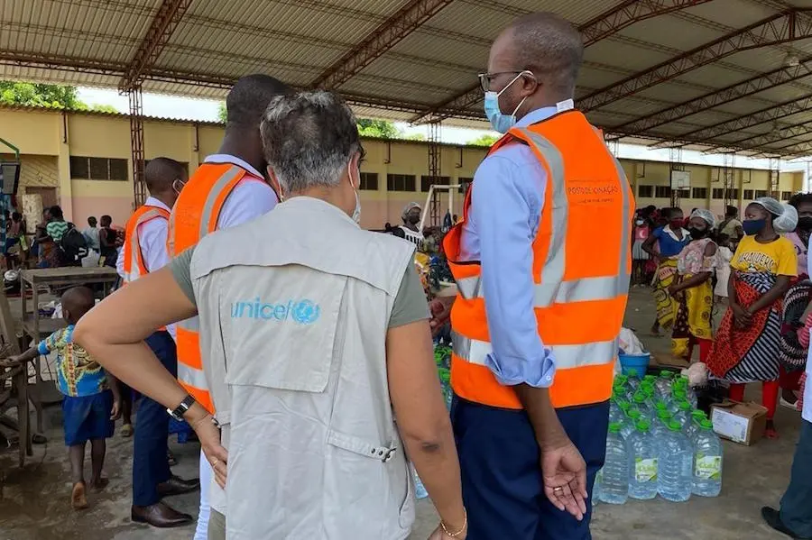 On January 27, 2022, families arrive and receive UNICEF support at a site for Internally Displaced People (IDP) in Tete, northern Mozambique, hosting at least 1,200 people after Tropical Storm Ana hit parts of the country. UNICEF emergency staff stand in an emergency shelter filled with people displaced by Tropical Storm Ana in Mozambique.