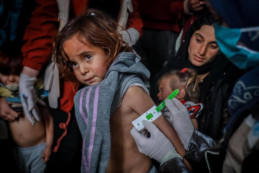 A UNICEF-supported health worker measures a child's mid-upper arm to screen for malnutrition at a site for families displaced by violence in Hasakah city, northeast Syria on January 24, 2022.