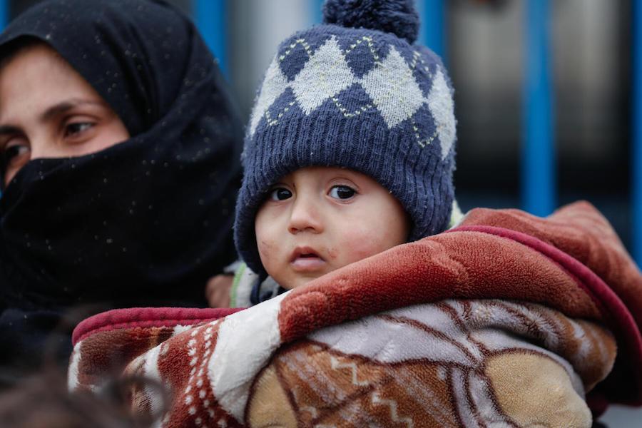 An internally displaced woman holds her son at Waleed Nofal school in Hasakah city, northeast Syria on January 27, 2022. 