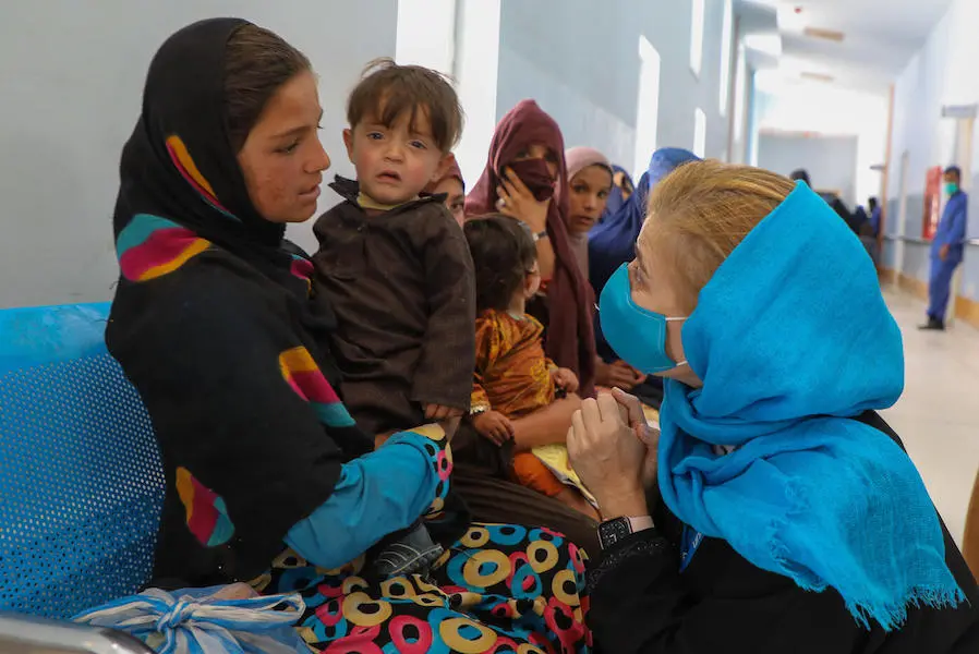 Paloma Escudero, Director of the UNICEF Division of Global Communication and Advocacy, talks to a young girl waiting with her little brother outside the immunization unit at Paktya Regional Hospital in Gardez, Afghanistan on April 16, 2022. Paloma Escudero, Director of the UNICEF Division of Global Communication and Advocacy, talks to a young girl waiting with her little brother outside the immunization unit at Paktya Regional Hospital in Gardez, Afghanistan on April 16, 2022.