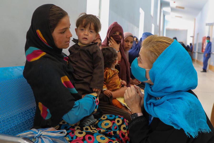 Paloma Escudero, Director of the UNICEF Division of Global Communication and Advocacy, talks to a young girl waiting with her little brother outside the immunization unit at Paktya Regional Hospital in Gardez, Afghanistan on April 16, 2022.