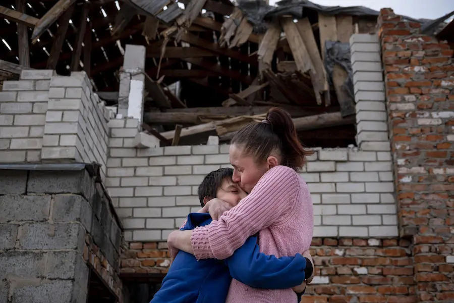 Olena, 43, holds her son, Mikhailo, 9, in a tight embrace, and kisses him, as they are reunited in front of their damaged home in Novoselivka, outside of Chernihiv, Ukraine after a month apart. Olena, 43, holds her son, Mikhailo, 9, in a tight embrace, and kisses him, as they are reunited in front of their damaged home in Novoselivka, outside of Chernihiv, Ukraine after a month apart.