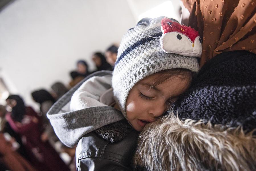 Ishak sleeps on his mother's shoulder while waiting for his checkup from a UNICEF-supported mobile health team in Rural Damascus, Syria on March 8, 2022.