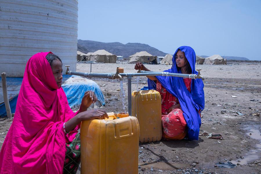 Two girls in Ethiopia's drought-affected Afar region draw safe water from a UNICEF-supplied water source.