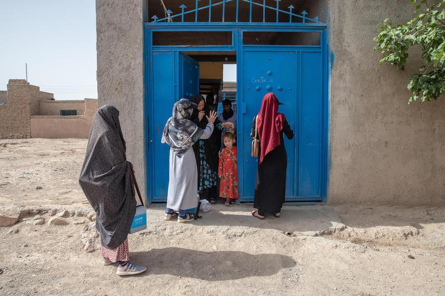 A UNICEF-supported female polio vaccination team is welcomed into a family compound in Afghanistan's Herat Province.