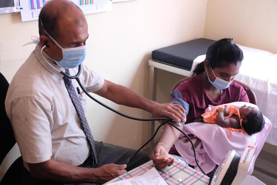 Dr. Ruwan Jayasingha from Sri Lanka's Ministry of Health conducts a health checkup of a mother at the UNICEF-supported clinic in Hatton, Sri Lanka on June 3, 2022.