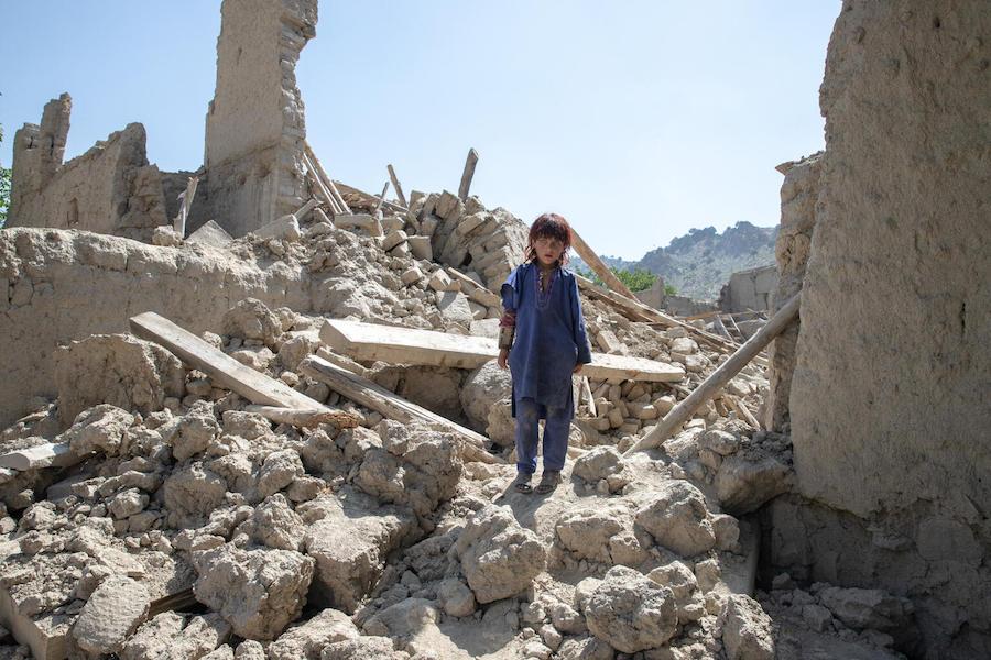 Six-year-old Zaid Allah stands in the ruins of his family's home, destroyed by the June 22, 2022, earthquake in southeastern Afghanistan.