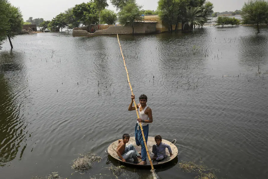 Children use a jaggery cooking pan as a boat in flooded Khairpur district, Sindh Province, Pakistan, on Sept. 12, 2022. Children use a jaggery cooking pan as a boat in flooded Khairpur district, Sindh Province, Pakistan.