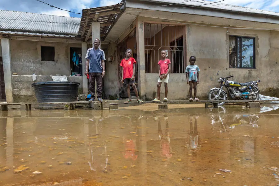 Akpoebi Germany, far left, and his children rigged up a makeshift wooden walkway over the flooded yard outside their home in Sagbama, Bayelsa State, Nigeria. Akpoebi Germany, far left, and his children rigged up a makeshift wooden walkway over the flooded yard outside their home in Sagbama, Bayelsa State, Nigeria.