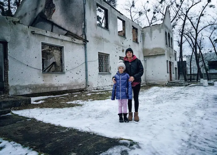 Two People Standing in Front of Burnt Building