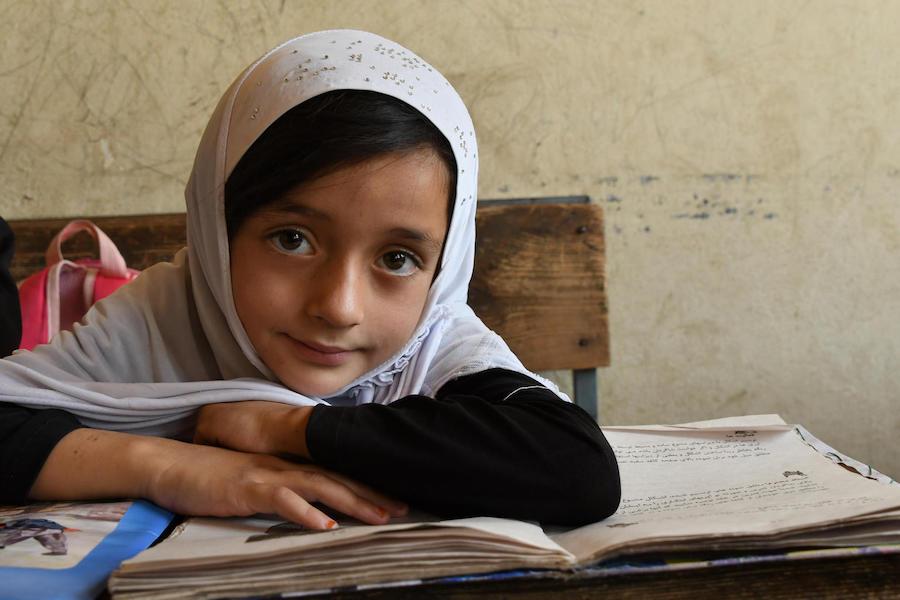 In August 2019, a girl looks up from her studies at the Turgani High School in the city of Faizabad, Badakhshan province, in northeastern Afghanistan. 