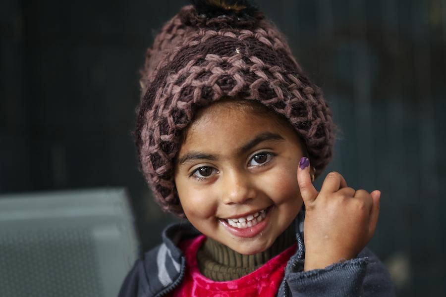 A girl in Pakistan shows the ink mark on her finger that she received after being vaccinated against polio during a UNICEF supported immunization campaign.