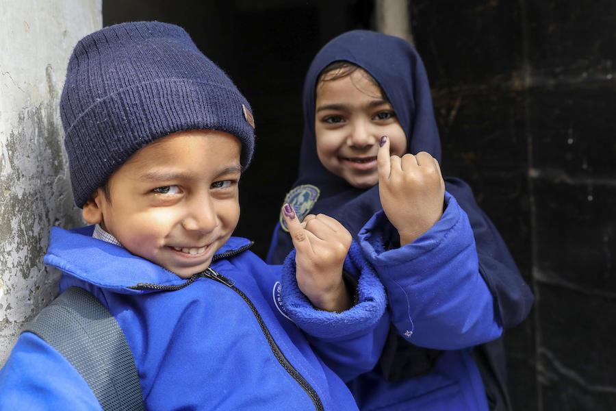 Five-year-olds Abdullah (left) and Mariyam show the ink marks confirming they have received the polio vaccine in the Ponch house area of Lahore Punjab Province, Pakistan in January 2019.