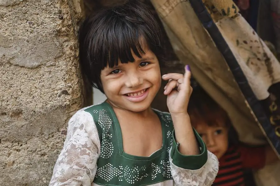 Anila (4) shows ink mark on her little finger, which confirms that she has received polio vaccine during Polio – National Immunisation Day (NID) in Gadab town, Karachi Sindh Province, Pakistan. Anila (4) shows ink mark on her little finger, which confirms that she has received polio vaccine during Polio – National Immunisation Day (NID) in Gadab town, Karachi Sindh Province, Pakistan.