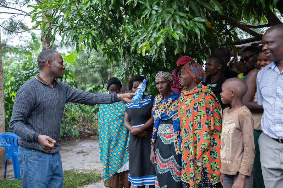 A UNICEF health worker shows community members a bottle of drinking water contaminated with feces during an education session in western Uganda's Kamwenge district in 2019. A UNICEF health worker shows community members a bottle of drinking water contaminated with feces during an education session in western Uganda's Kamwenge district in 2019.