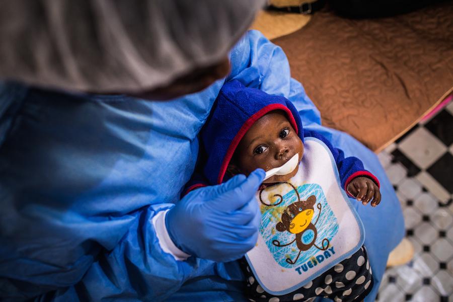 A UNICEF supported caregiver in the Democratic Republic of Congo feeds a baby whose mother has died after being infected with the Ebola virus.