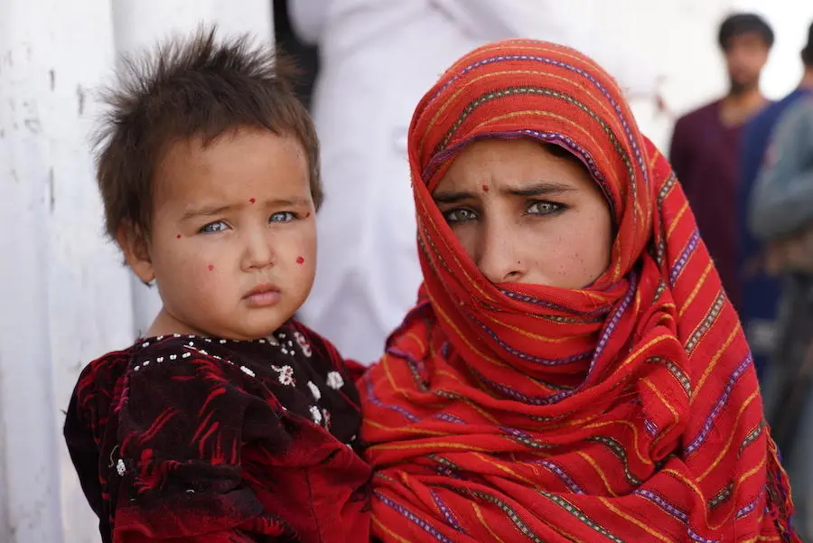 In December 2019, 12-year-old Yasamin holds her baby sister, Aisha Gul, outside a nutrition center in a camp for internally displaced people near the city of Herat in western Afghanistan. In December 2019, 12-year-old Yasamin holds her baby sister, Aisha Gul, outside a nutrition center in a camp for internally displaced people near the city of Herat in western Afghanistan.