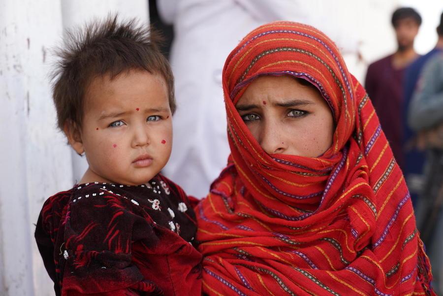 In December 2019, 12-year-old Yasamin holds her baby sister, Aisha Gul, outside a nutrition center in a camp for internally displaced people near the city of Herat in western Afghanistan. 