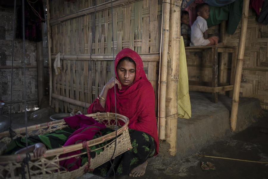 On December 2, 2019, at Balukhali refugee camp in Cox’s Bazar, Bangladesh, Kulsum Bahar, 27, holds two dresses belonging to her daughter, Jannatara, 8, who went missing fourteen months ago on her way from their home to a learning center in the camp. 