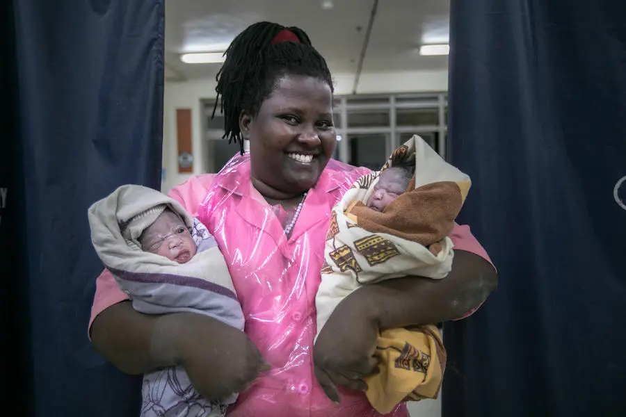Kabusinge Madrine, a midwife at Kawempe Referral Hospital in Uganda, holds newly delivered twin girls, Babirye and Nakato on January 1, 2020. Kabusinge Madrine, a midwife at Kawempe Referral Hospital in Uganda, holds newly delivered twin girls, Babirye and Nakato on January 1, 2020.