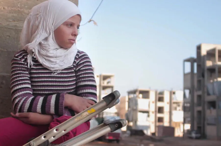In Aleppo, Syria in 2016, 12-year-old Saja watches friends playing football. She lost her leg in a bomb blast at age 11. In Aleppo, Syria in 2016, 12-year-old Saja watches friends playing football. She lost her leg in a bomb blast at age 11.