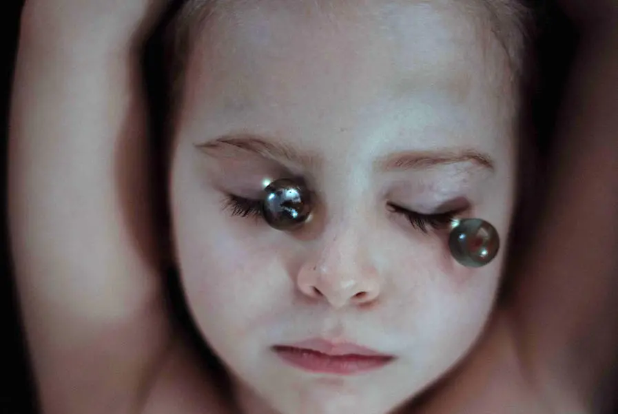 Child Posing with Marbles