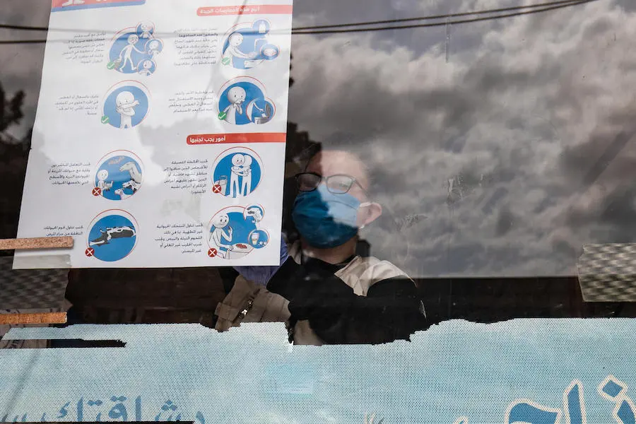 On April 1, 2020, a UNICEF volunteer hangs posters providing important instructions on how to protect against COVID-19 in Qamishly, a city of some 250,000 in northeast Syrian Arab Republic. On April 1, 2020, a UNICEF volunteer hangs posters providing important instructions on how to protect against COVID-19 in Qamishly, a city of some 250,000 in northeast Syrian Arab Republic. 
