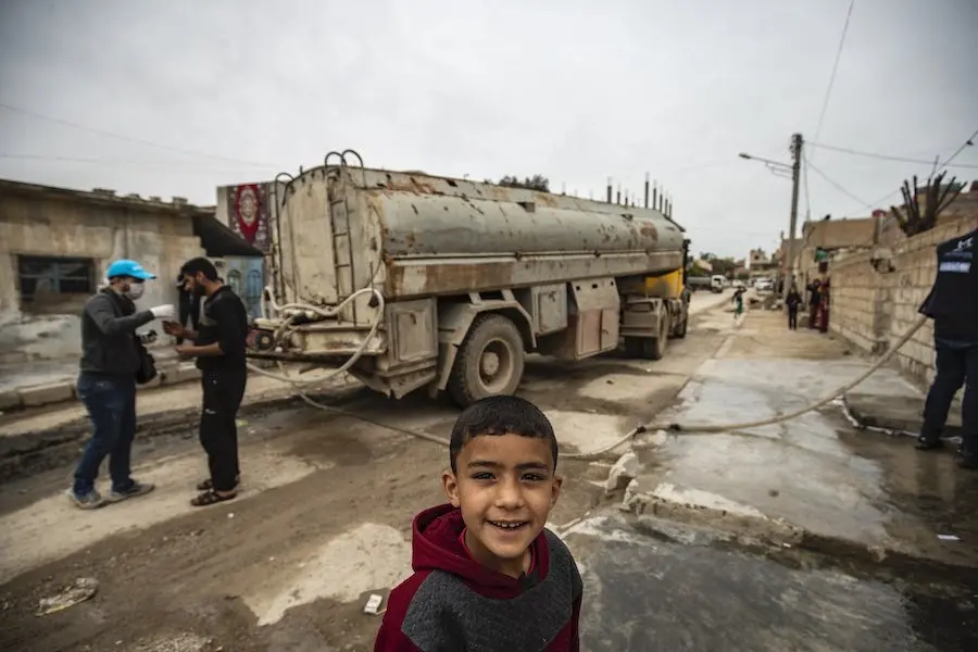 Boy in Front of Water Truck