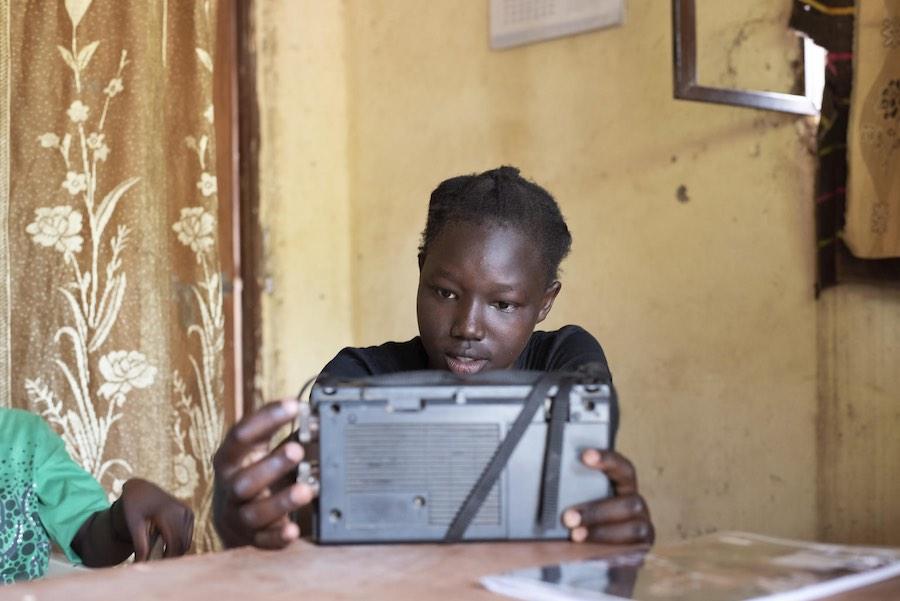 Angures Buba (14) is tuning in on the educational radio lessons. Angures is in primary 8, and the lessons today are covering Engllish and Sience. Angures lives in the campital Juba, in a part of town called Munuki.