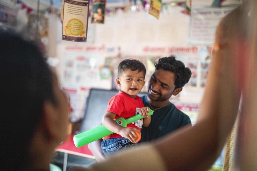 Chetan Mhaske takes care of his child, Ryan, at one of India’s Anganwadi centers.