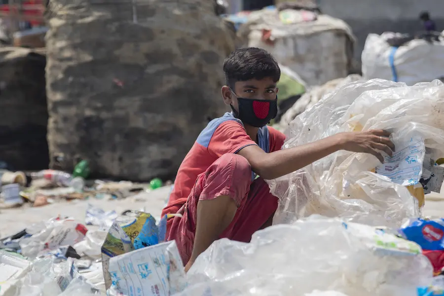 Miajul, 12, sorts through plastic waste at a dump in Shyamol Palli, Dhaka, Bangladesh, looking for material he can sell to recyclers. Miajul, 12, sorts through plastic waste at a dump in Shyamol Palli, Dhaka, Bangladesh, looking for material he can sell to recyclers.