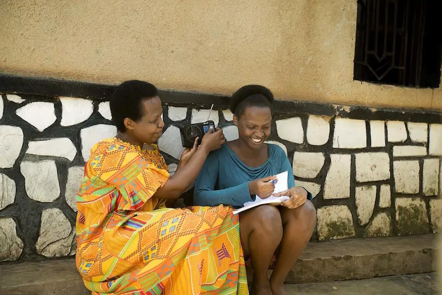 Samantha, 17, listens to radio lessons with her mother, Kayirangwa Mary Assoumpta, outside their home in Rwanda. Samantha, 17, listens to radio lessons with her mother, Kayirangwa Mary Assoumpta, outside their home in Rwanda.