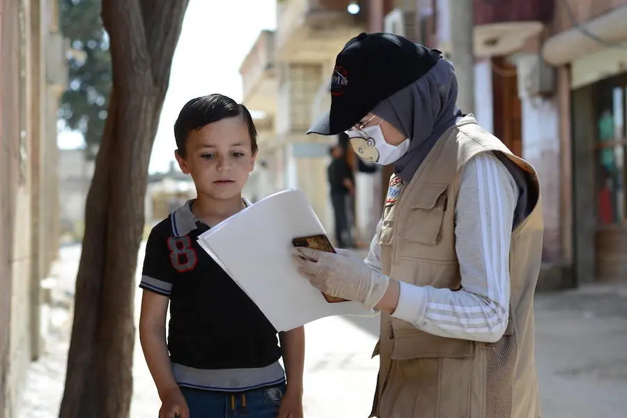On May 14, 2020, UNICEF-supported volunteer Aya, 24, talks with a boy about COVID-19 in the war-ravaged village of Teir-Ma'aleh, Homs, Syria. On May 14, 2020, UNICEF-supported volunteer Aya, 24, talks with a boy about COVID-19 in the war-ravaged village of Teir-Ma'aleh, Homs, Syria.