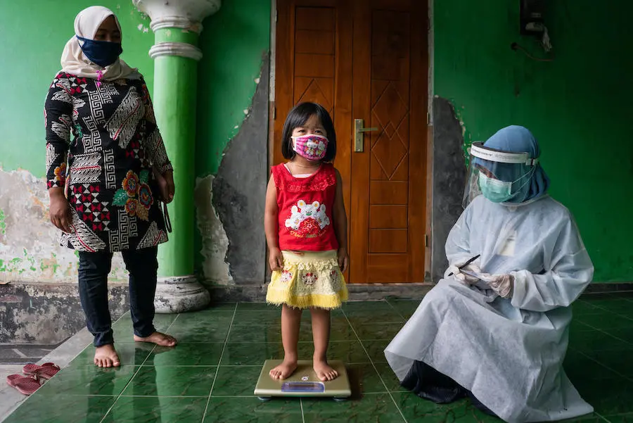 A child is weighed at a community health post in Sidorejo village, Central Java province, Indonesia, as part of a routine health and nutrition check. A child is weighed at a community health post in Sidorejo village, Central Java province, Indonesia, as part of a routine health and nutrition check.