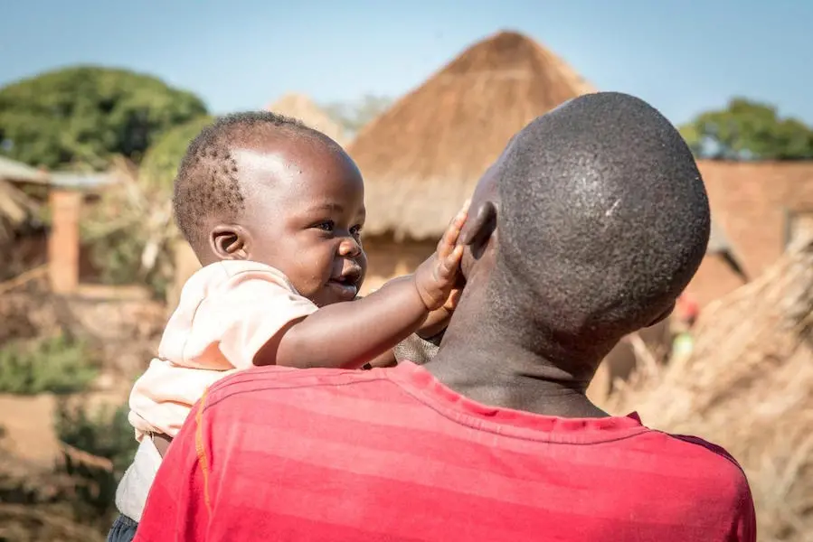 Baby Reaching Out to Man Holding Them